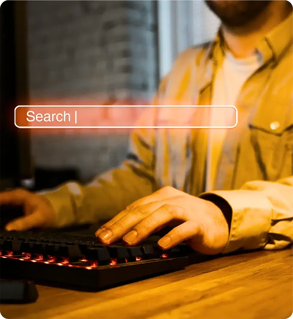 Hands typing into a search bar at a keyboard