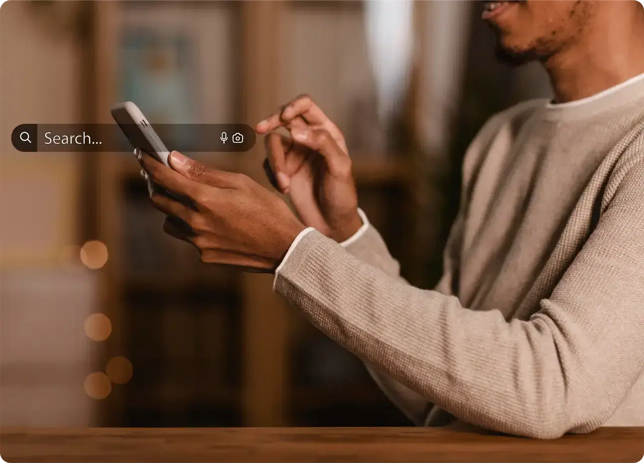 A man typing a name into a search bar on his phone