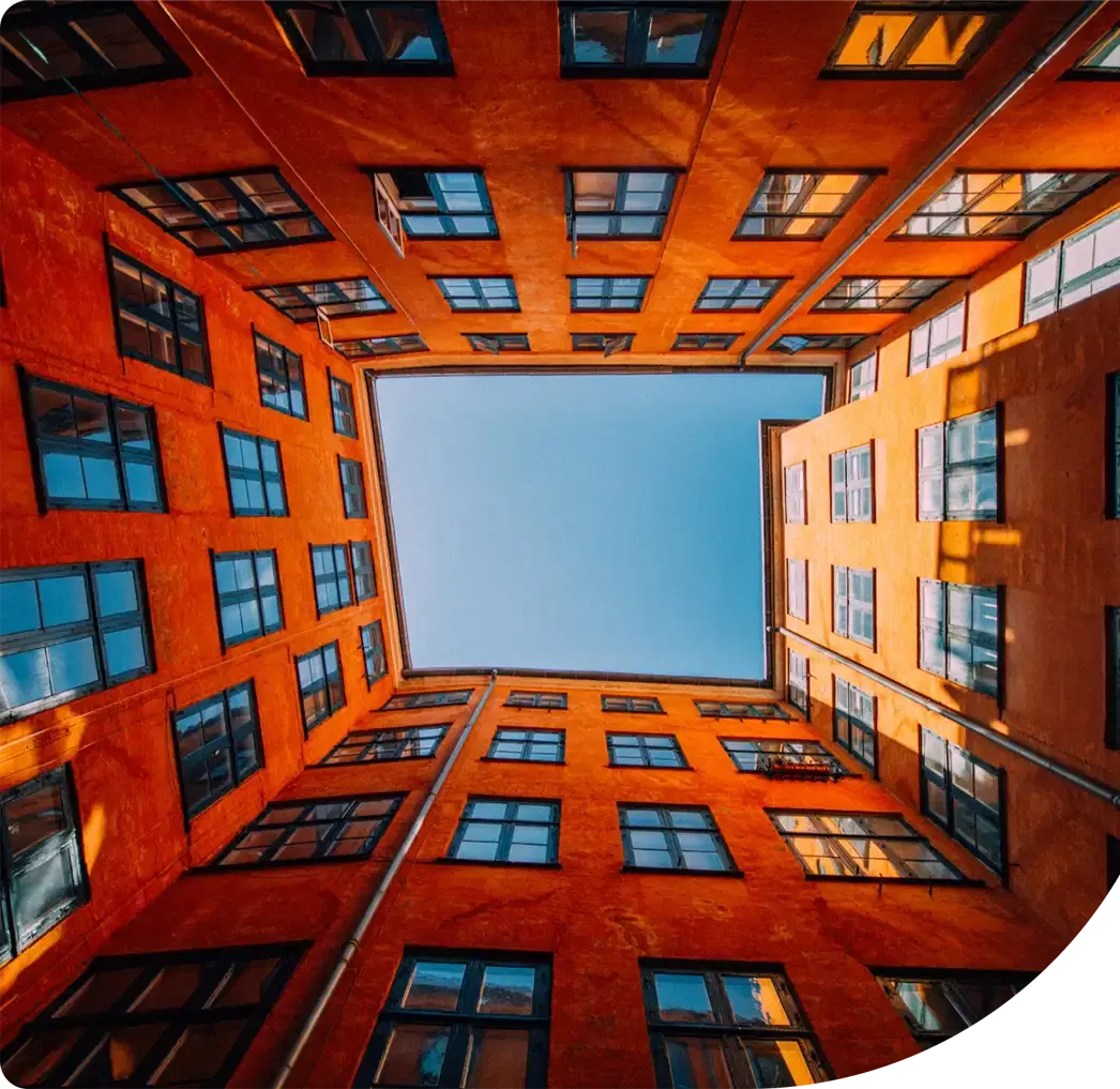 Looking up through an orange courtyard to the sky