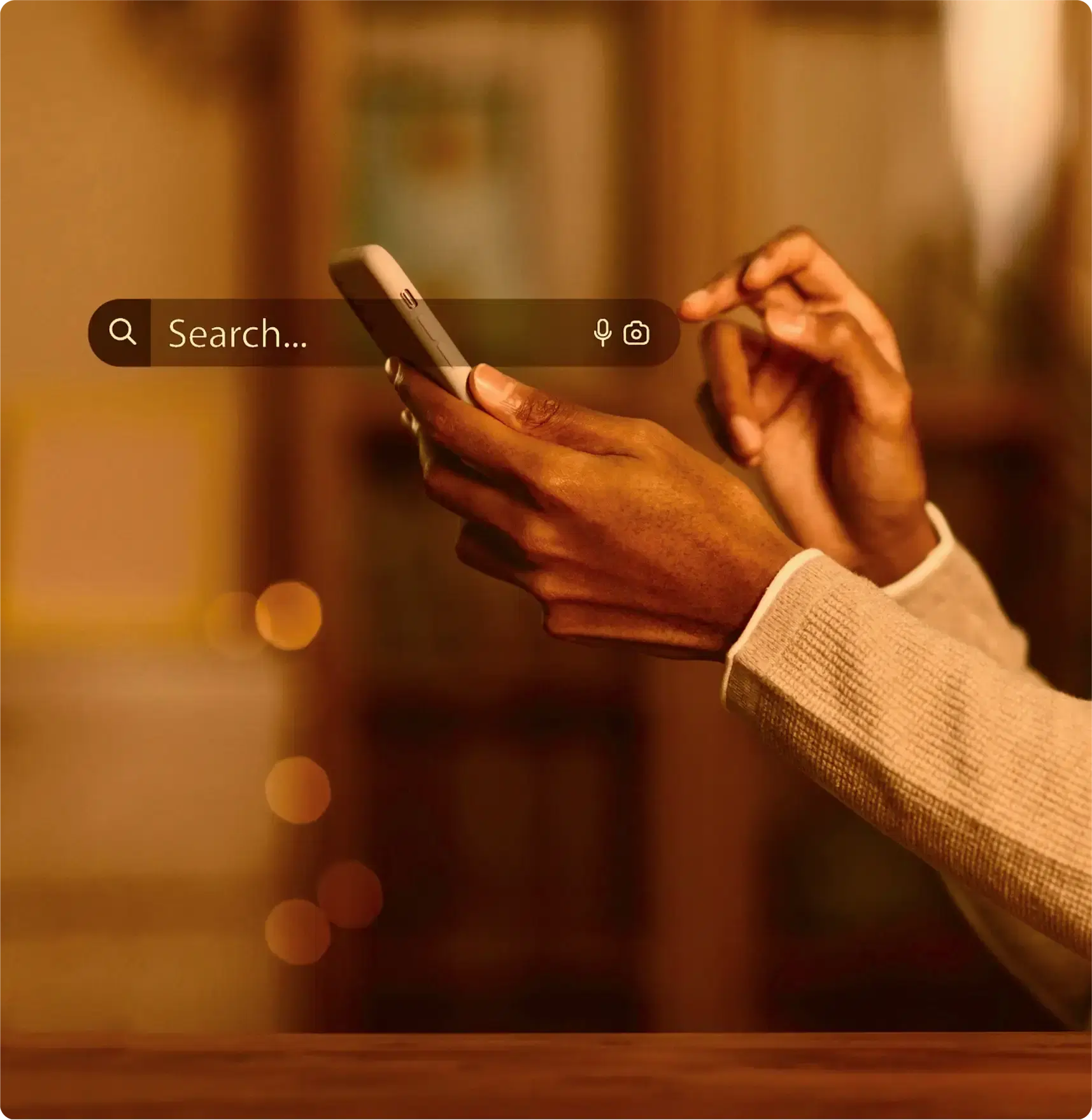 A search field held open over a phone in someone’s hand